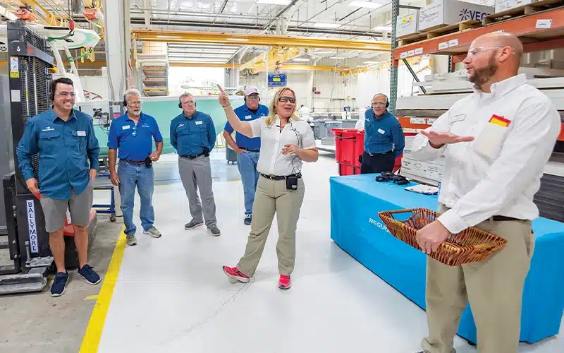 A regulator employee speaks to people touring the facility