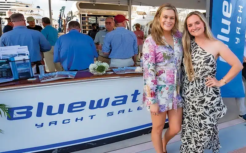 Kelsea Hall and Kristen Turk posing at the Bluewater Yacht Sales booth during a boat show event