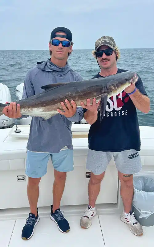 Cross Ferrara and a friend showing off their cobia catch on the deck of the Regulator 41