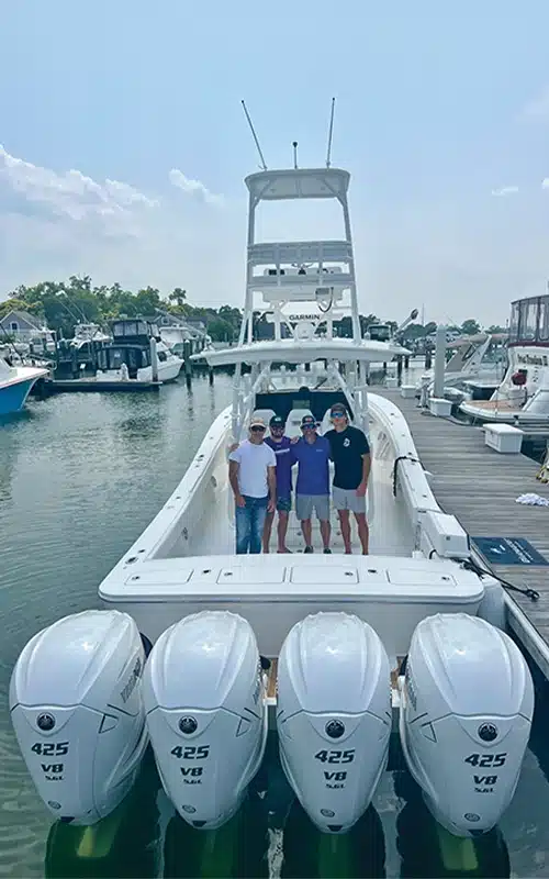 Cross Ferrara and friends standing at the stern of the Regulator 41, showcasing the quad Yamaha 425 V8 outboard engines