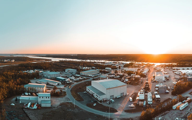 Aerial view of the current Jarrett Bay Boatworks facility, showing the expansive boatyard and production buildings at sunset